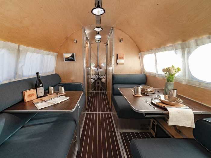 The Bowlus trailer includes an indoor and outdoor kitchen, living area, bedroom, and bathroom.