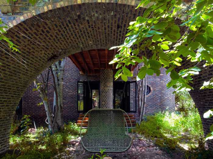 The "big arch" after which the house is named supports both an above-ground pool and a small swing bench.