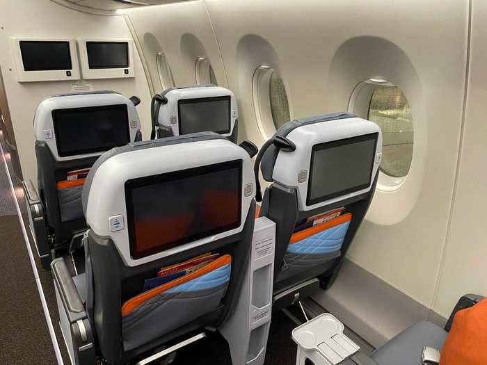 Amenities at each seat include a personal in-flight entertainment screen,  personal reading lamp, 110v AC power outlet, USB charging port, coat hangar, water bottle holder, adjustable headrest, and pillow and blanket kit.
