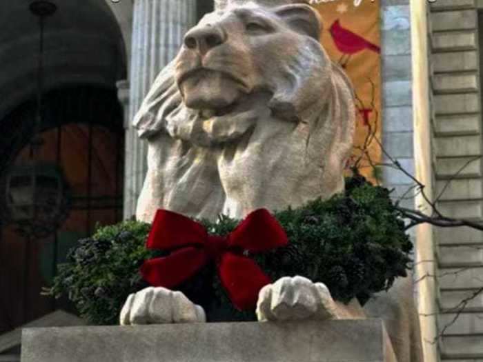 During a transition scene, the New York Public Library lion statues are shown looking festive.