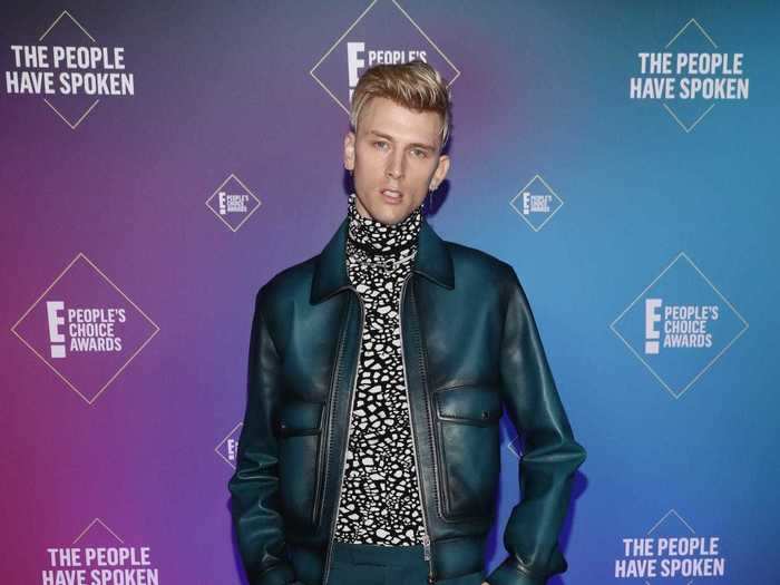 Machine Gun Kelly looked sleek in a blue leather jacket, matching pants, and white boots.