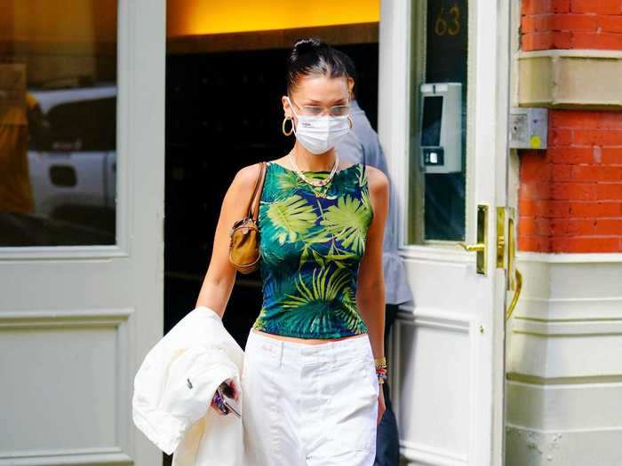 In September, Hadid was photographed wearing a bright tropical-print top, white jeans, sneakers, a jacket, and a small shoulder bag.