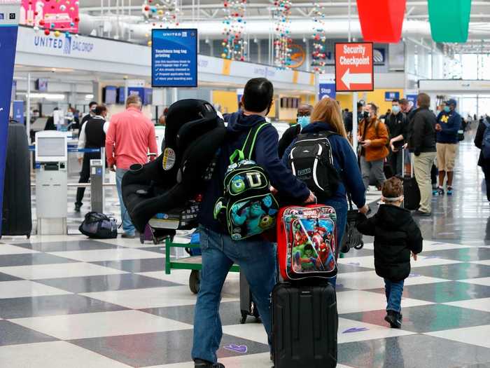 People line up at baggage drop kiosks at O