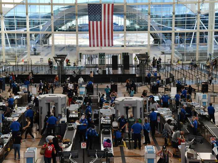 TSA crew and travelers wore masks at the security checkpoint at the Denver International Airport on Friday .