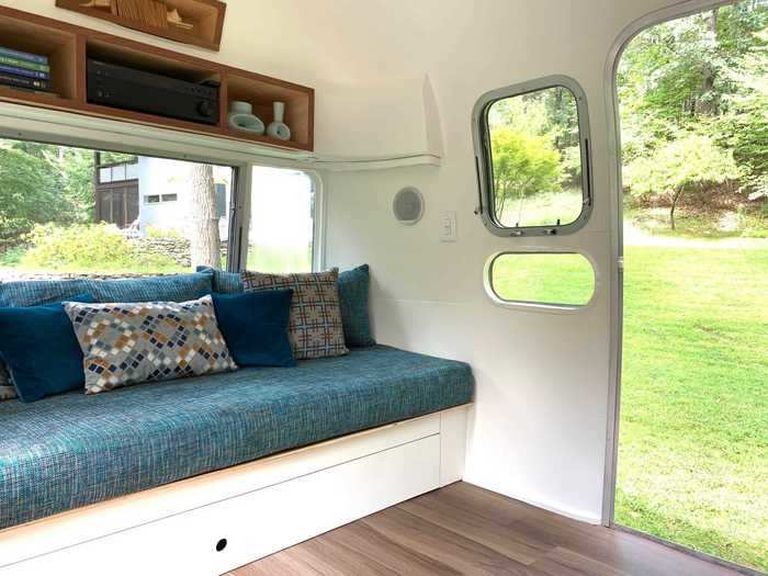 In place of the dusty, disintegrating coach and stained carpet is a custom blue daybed and wood floor.