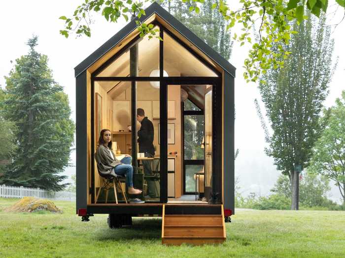 The DW tiny home includes unique features like a floor-to-ceiling window and a glass wall.