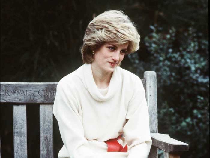 Princess Diana was a vision in winter white while wearing this cowl-necked sweater, white skirt, red patent leather boots, and matching belt.