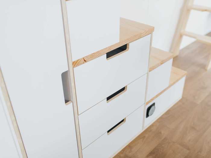 The staircase needed to access the bedroom has integrated storage units to maximize the tiny space.