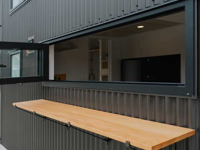 To enjoy food outside, Build Tiny also included a removable exterior countertop that can be accessed from the inside of the tiny home when the windows in front of the kitchen are opened.