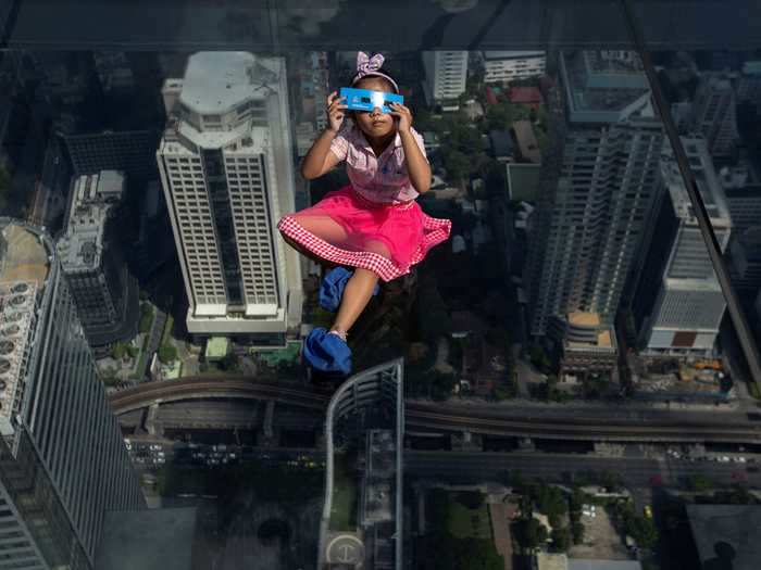 A child appears to be floating over Bangkok, but she