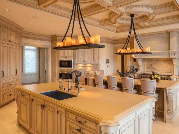 The gourmet kitchen features a double island and pantry.