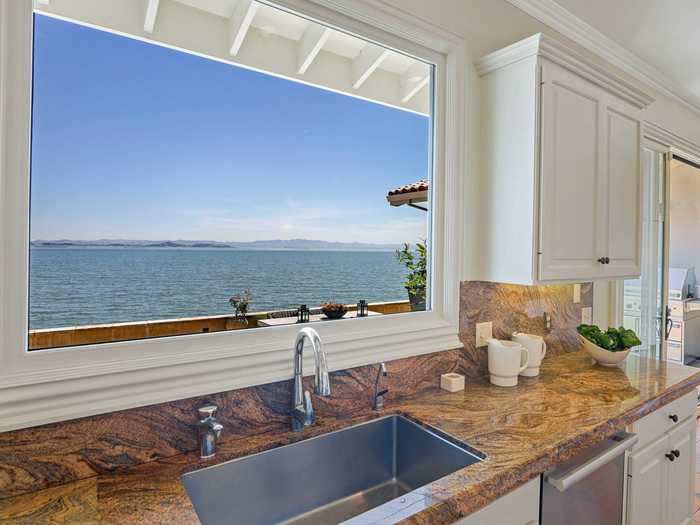 The listing describes the home as "inviting and elegant" with "open water views" throughout the home.