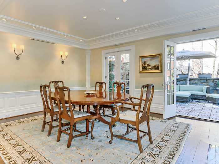 The formal dining room has a fireplace and opens up to a terrace.