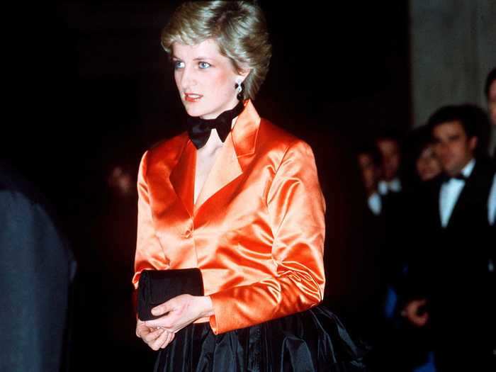 She wore a daring orange tuxedo look with a black bustle skirt in February 1987.