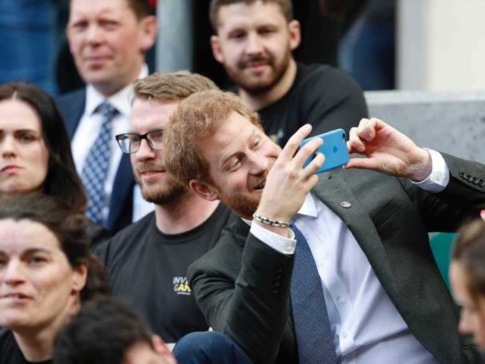 In 2017, Harry was spotted taking a photo on his cell phone as he watched the Invictus Games.