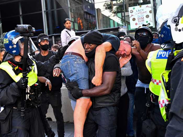 In the summer, hundreds of demonstrators, some of whom belonged to far-right groups, clashed with police during a protest in London. This picture,- of a BLM supporter carrying an injured counter-protester to safety - made national headlines.