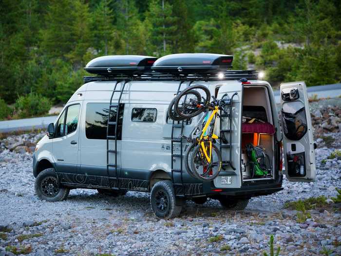 The exterior of the van has also been upgraded with accessories like a rear step bumper, utility ladders, an awning, a combo roof rack and light bars, and more.