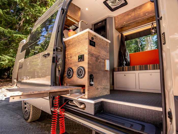 The kitchen also has built-in speakers and a table that can extend outside the van for said outdoor cooking.