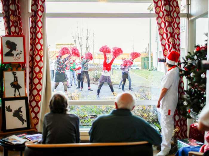 At a retirement home outside of Paris, workers performed outside while residents watched through a large window.