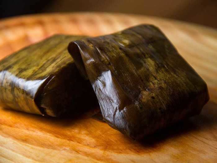 After midnight mass, Costa Ricans typically eat a meal featuring chicken and pork tamales wrapped in plantain leaves.