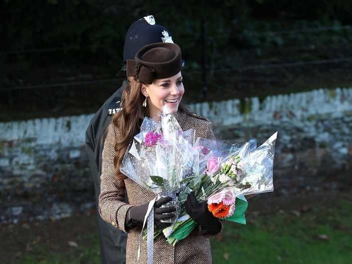 Kate Middleton wore an elegant, long brown coat and pillbox hat in 2014.