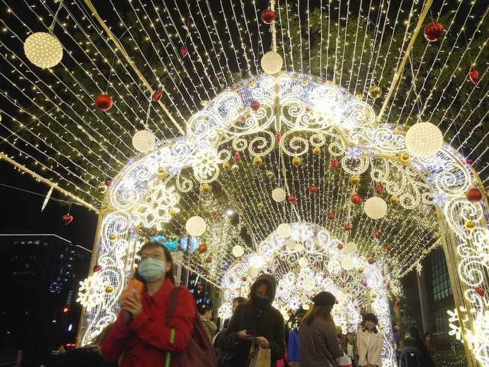 Face mask-clad city-goers in Taipei, Taiwan, walked through a display with lanterns and string lights on Christmas Eve.