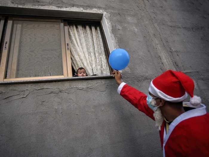 Santa Claus characters around the world greeted people through windows on Christmas Eve and Christmas Day.