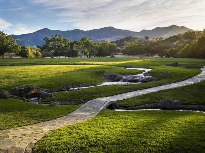 The ranch is secured by a gate, and a long, scenic road weaves through the property