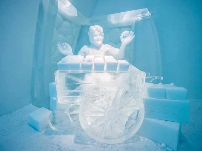 The room features a snow sculpture depicting Stordalen as a young boy, holding up strawberries and standing behind a strawberry cart.