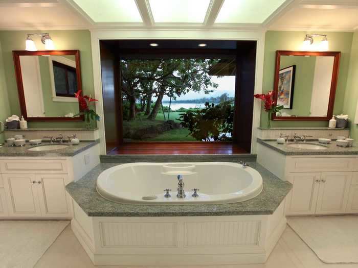 The master bathroom has a steam shower and a deep soaking tub with views of the water.
