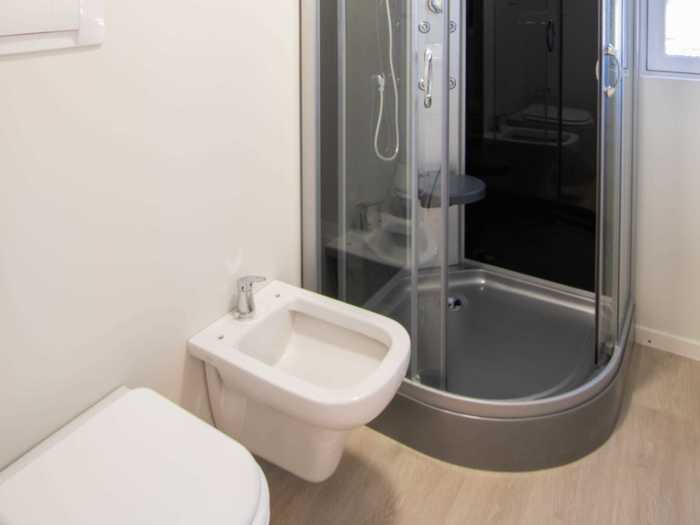 The bathroom - which has a shower, sink, and toilet - then separates the kitchen from the bedroom.