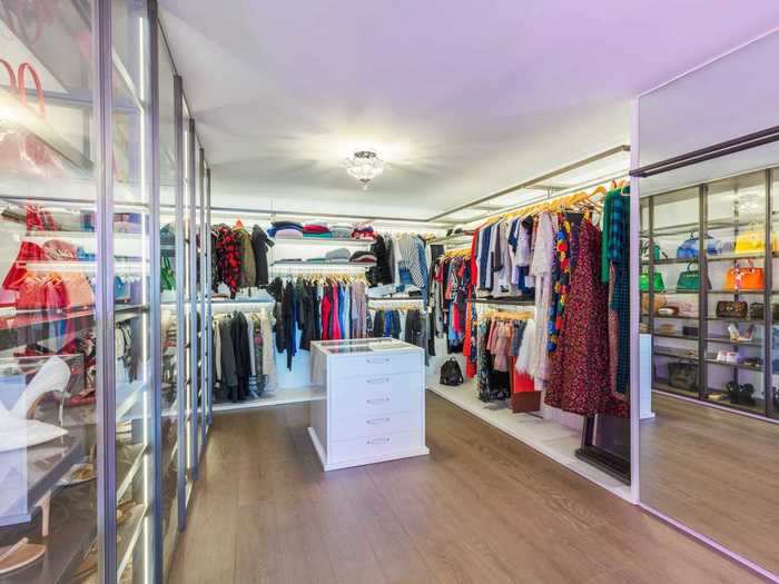 The listing photos show spacious his and hers dressing rooms with expertly displayed clothing, handbags ...