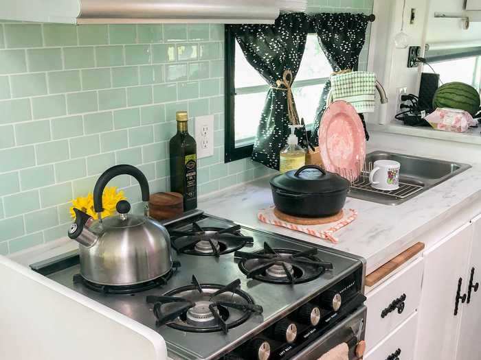 The kitchen includes all the necessities - a stovetop, oven, sink, and fridge.