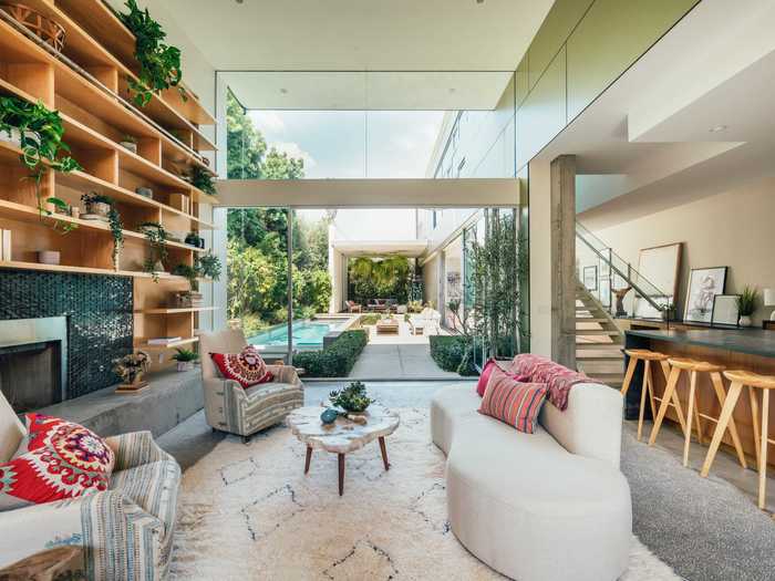 The living room has floor-to-ceiling windows and doors on two sides, with one leading to a courtyard ...