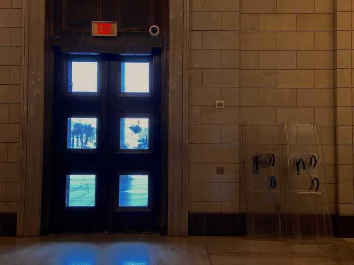 But just off the next room, the Capitol Rotunda, this doorway showed telltale marks of a riot. One of the middle panes had a huge crack, projectile marks peppered the door frame, and riot shields were propped nearby.