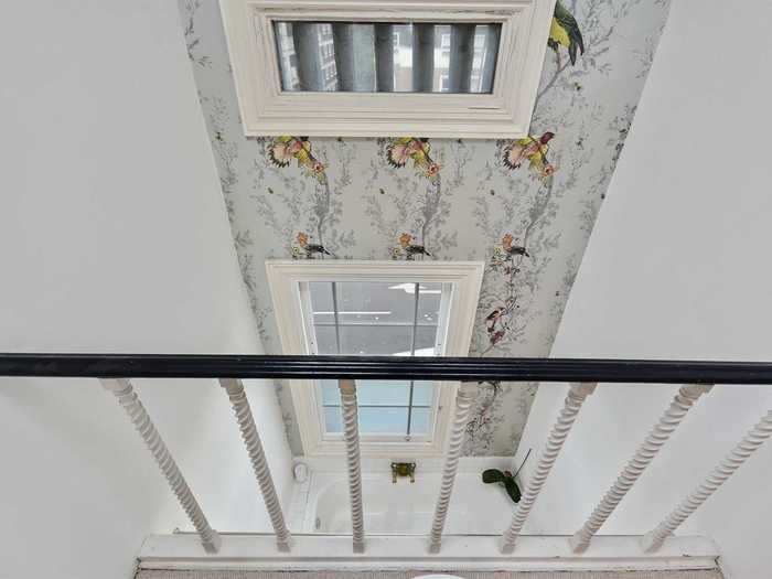 A mezzanine on the top floor overlooks the bathroom and feature wall.