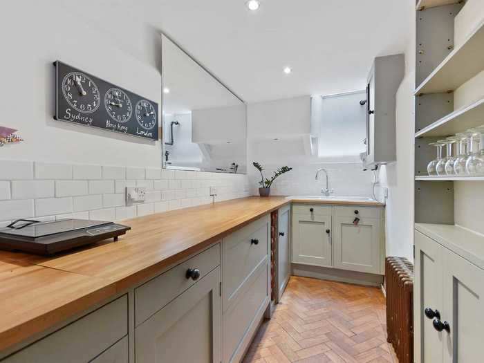 The kitchen is found on the basement level, and uses light colors and mirrors to create an airy, spacious feeling.