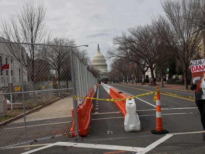 Pedestrian walks with a political sign near the Capitol building.