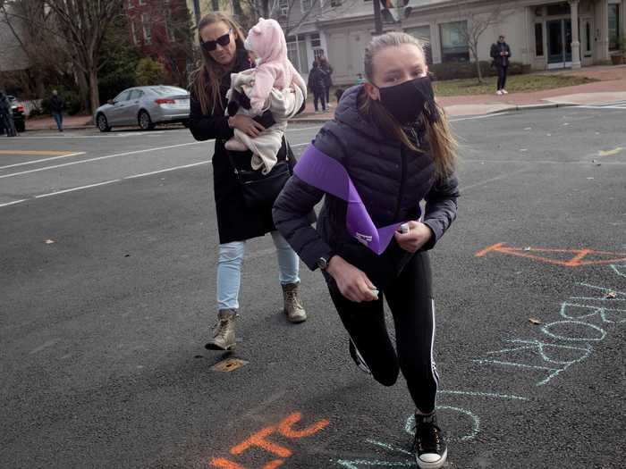 Anti-abortion activists chalk the residential streets of the Capitol Hill neighborhood.