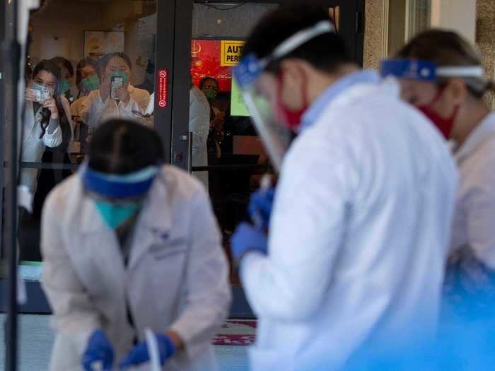 Pharmacists look out the door at Life Care Center Kirkland.