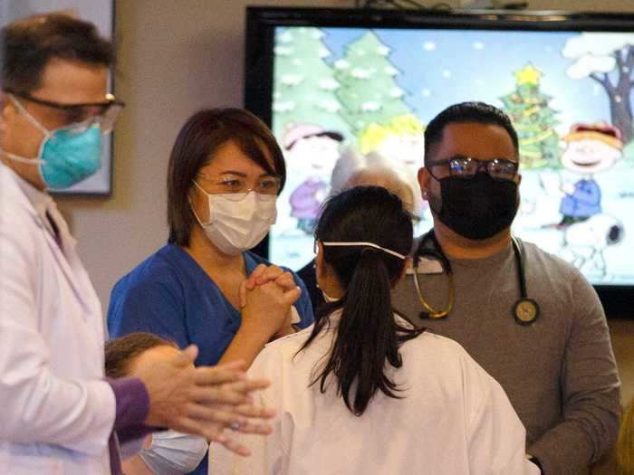 A physician assistant celebrates after receiving the vaccine.