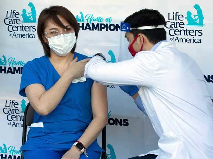 The nurse manager at Life Care Center of Kirkland receives the COVID-19 vaccine.