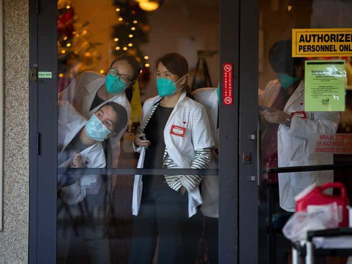 Pharmacists watch vaccinations at Life Care Center.