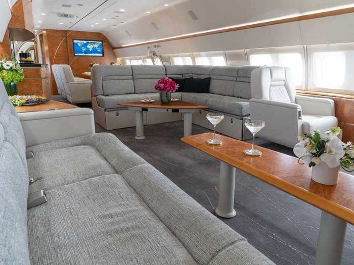 The living area of the plane features a mix of club seats and divans accompanied by a mid-cabin bar.