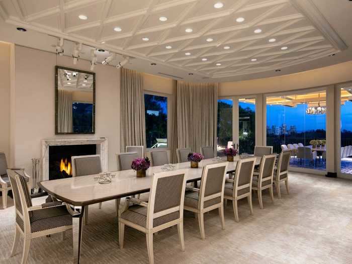 The formal dining room includes a fireplace and opens up to an outdoor space.