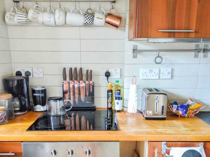 In the kitchen, Christian hung up mugs on the wall because she has "way too many" of them.