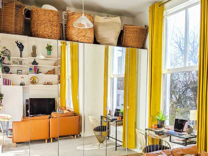 Behind the couch, a mirrored wardrobe amplifies the natural light in the room while making it feel much larger.