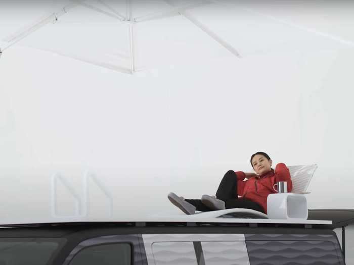 Work breaks can be taken outdoors on the roof of the van, which has a lounge chair, side table, and umbrella.