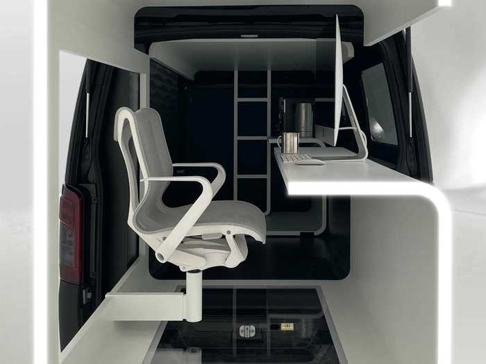 This retractable office space includes a desk, keyboard, mouse, monitor, and chair.