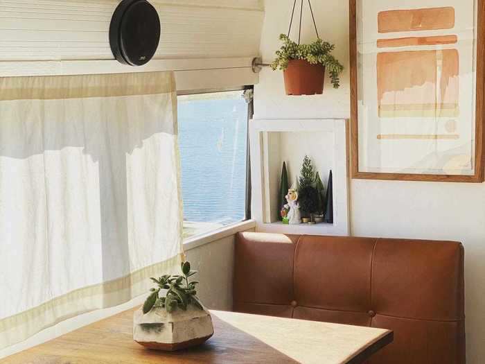 Across from the sink and cabinets, the leather dinette functions as the couple